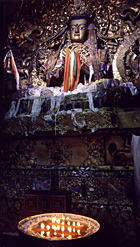 Statue of Maitreya lighted by butter lamps, Drepung Monastery